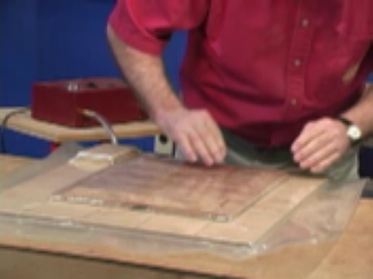 Raised panel door with bookmatched veneer being pressed inside vacuumm bag